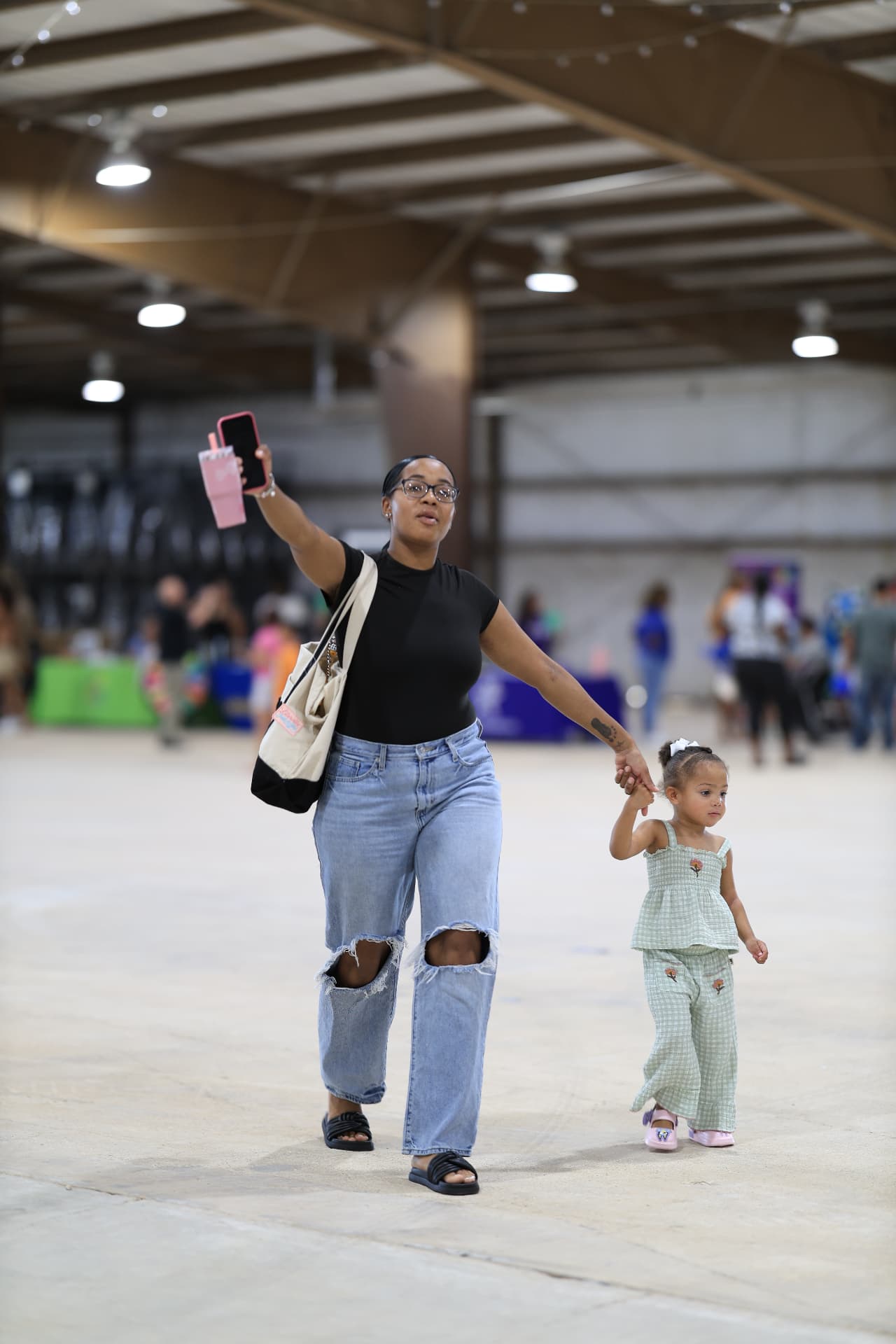 A mother and daughter walking hand in hand through the festival hall.