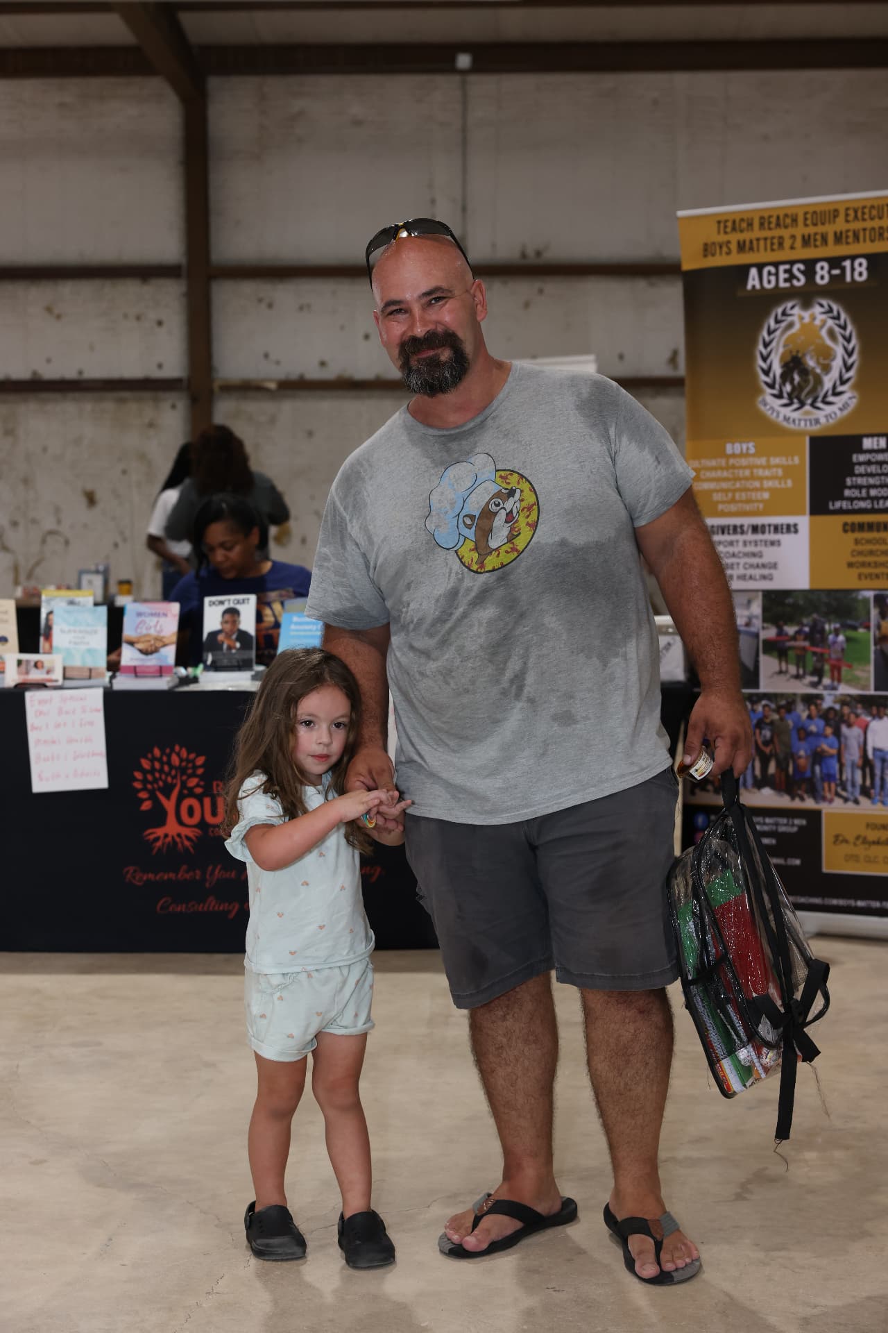 A father and daughter with a clear backpack at the Boys Matter 2 Men booth.