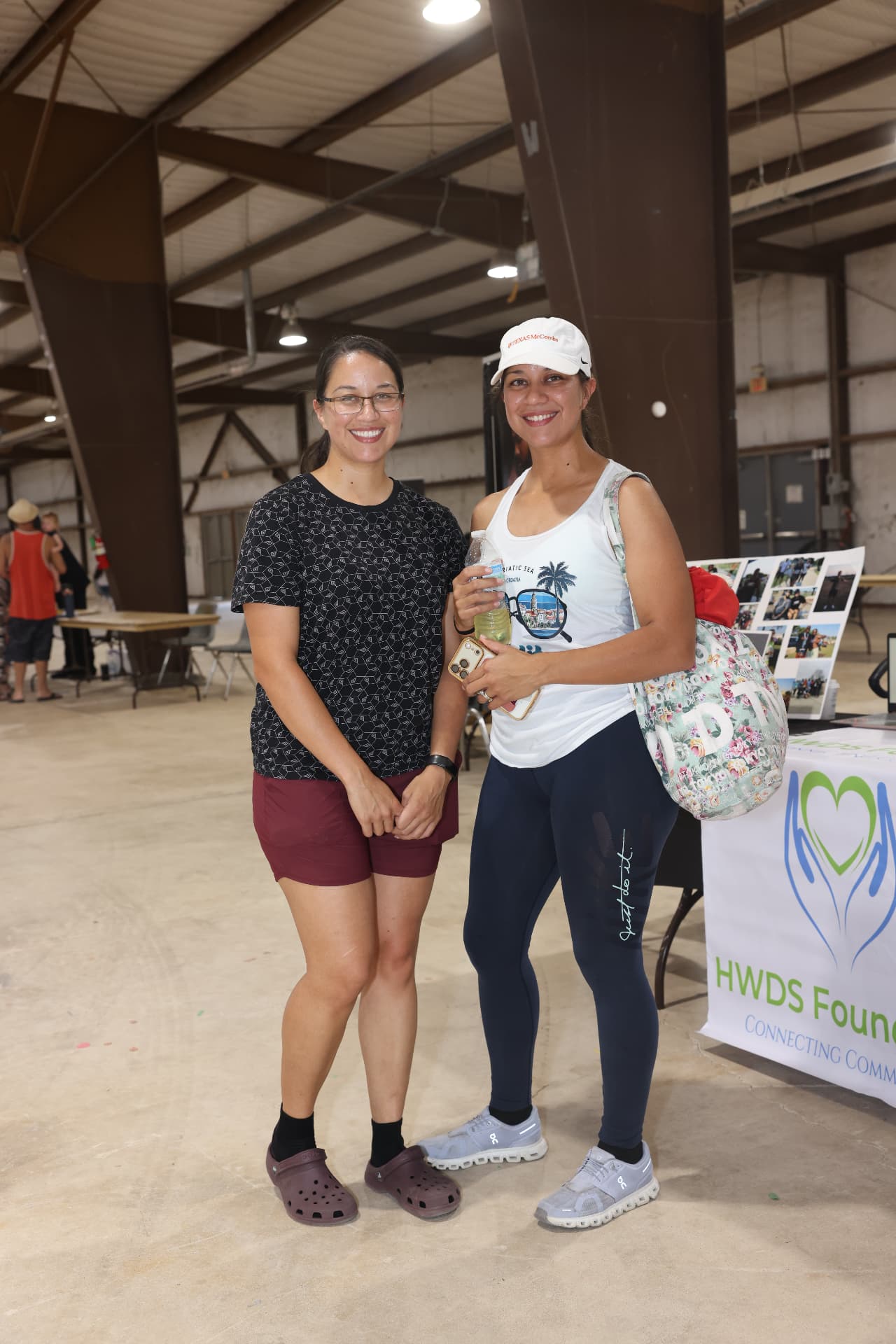 Two attendees posing together at the HWDS Foundation resource table.