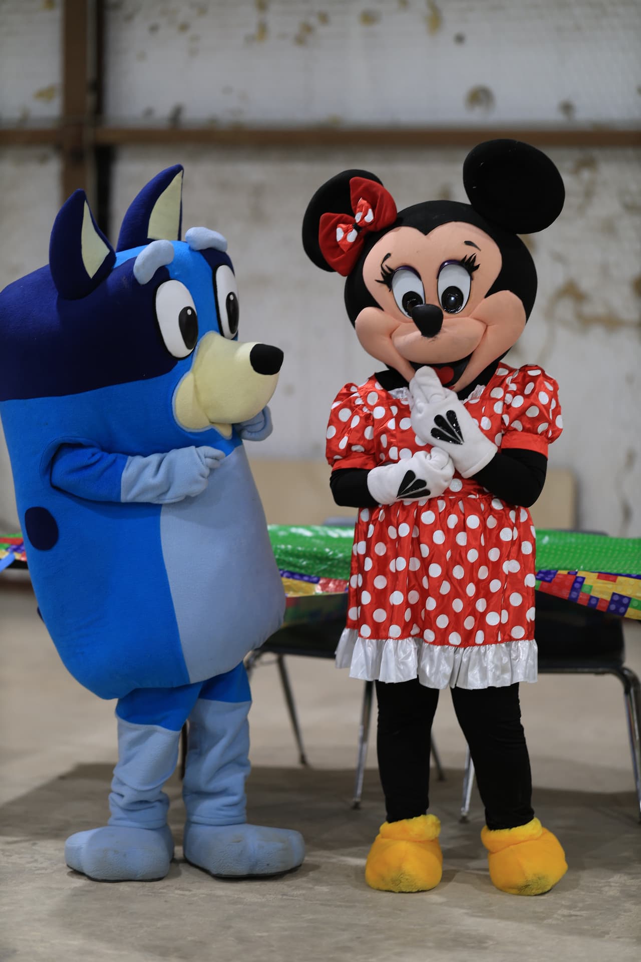 Costumed character mascots greeting children at the activity area.