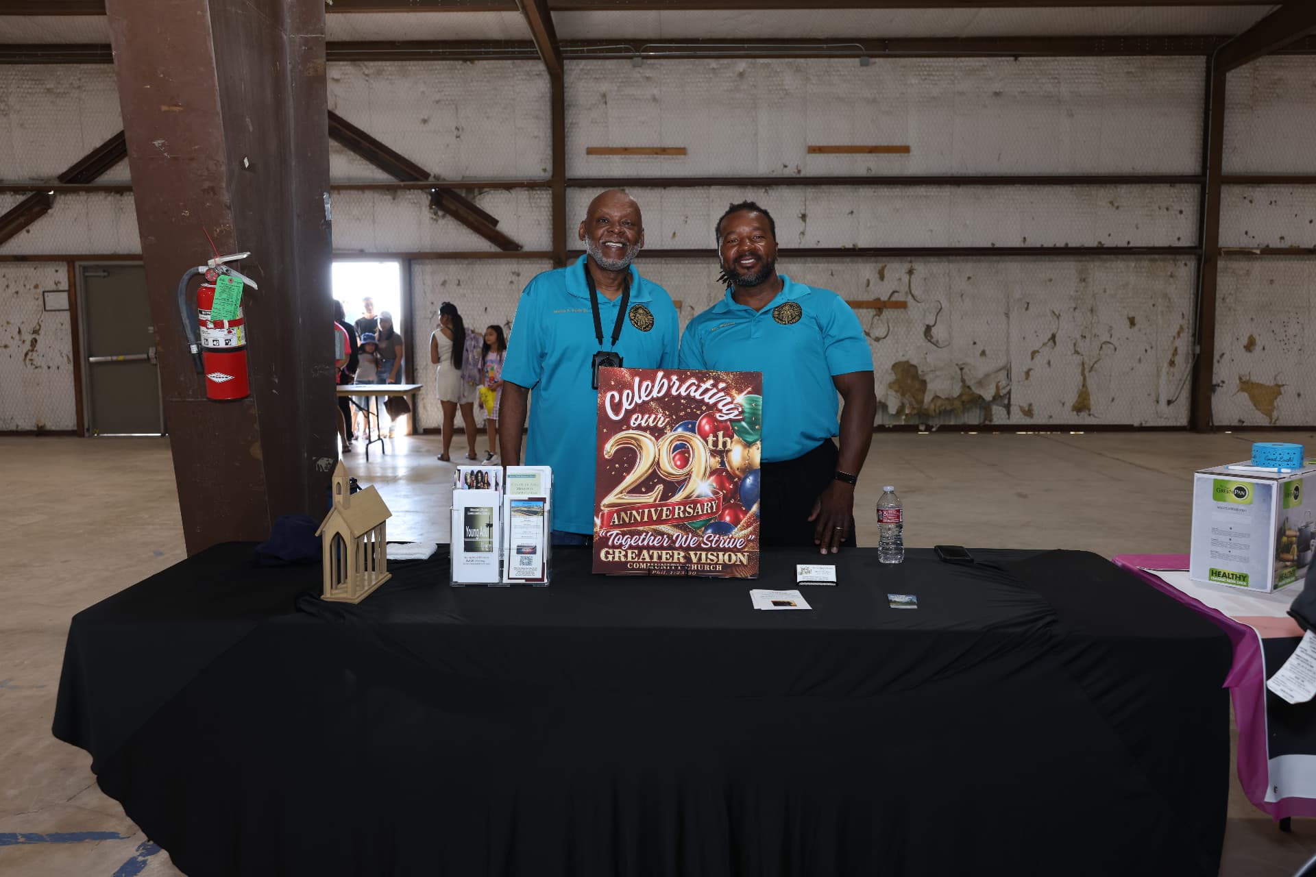 Two Greater Vision Community Church volunteers at their 29th anniversary table.