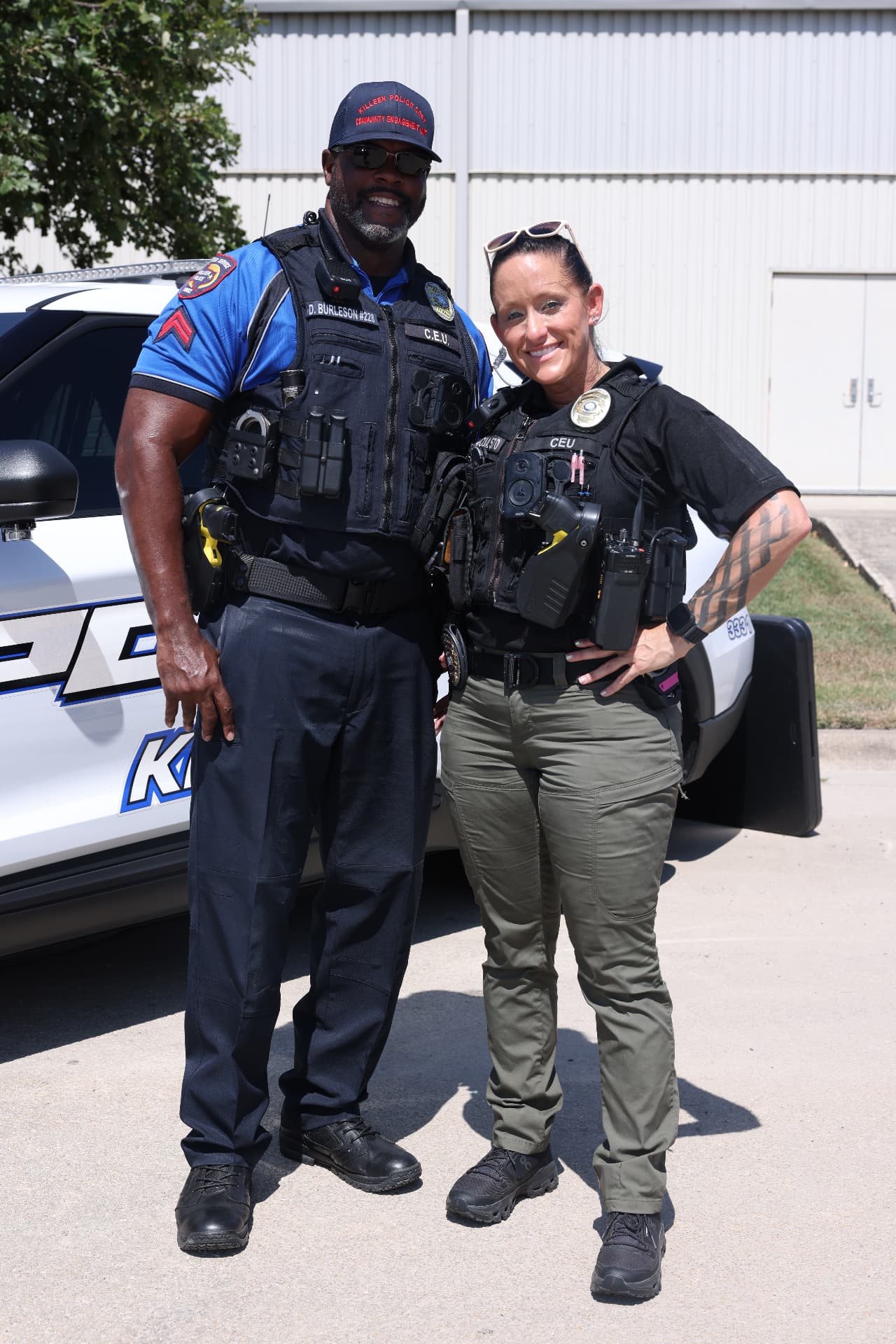 Two Killeen Police Community Engagement officers beside their patrol vehicle.