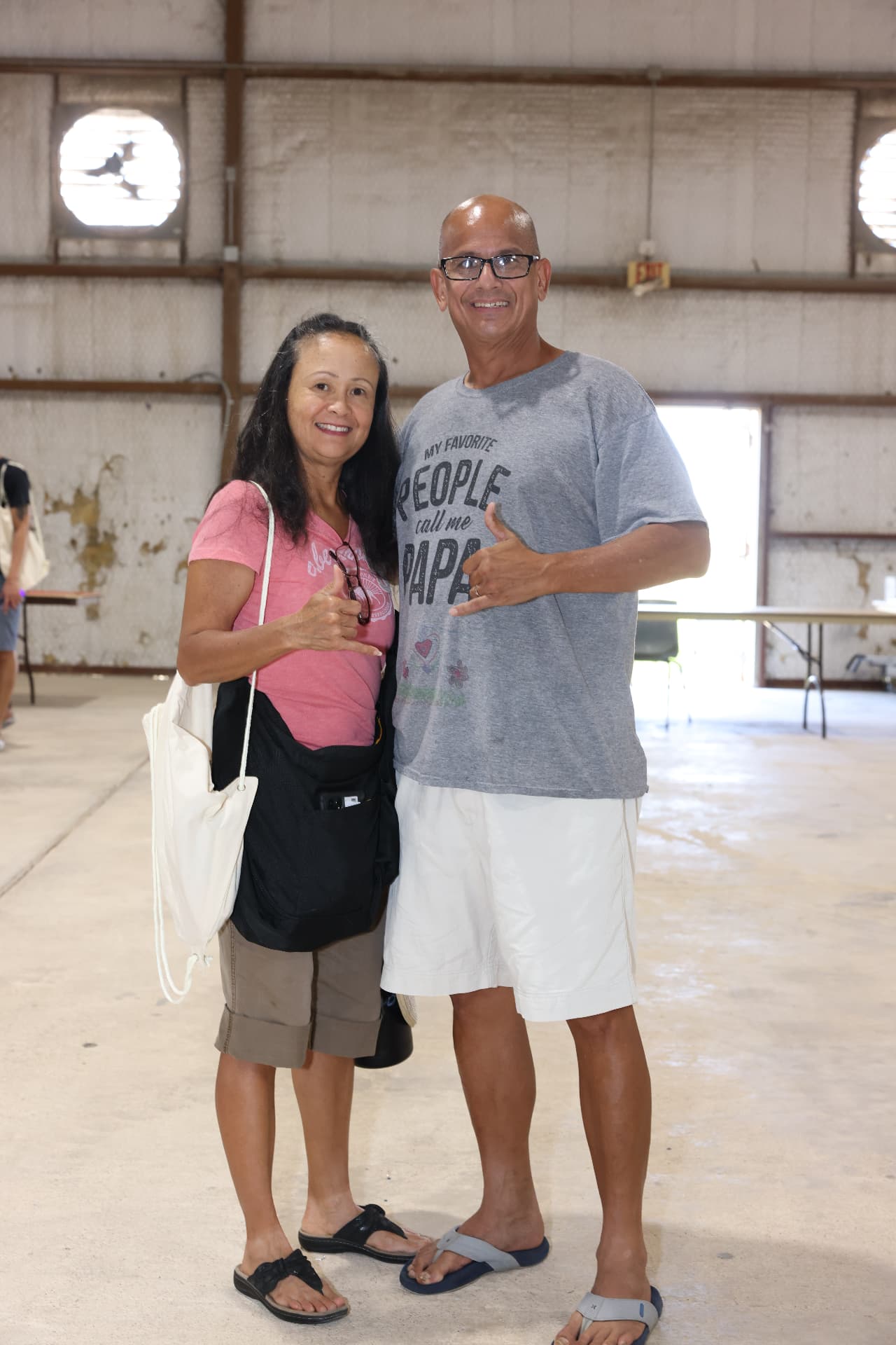 A couple smiling with festival giveaway bags.
