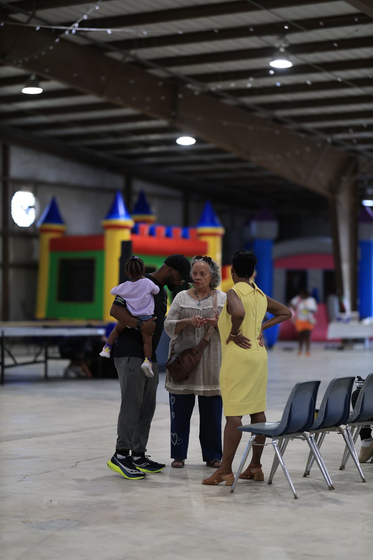 Families chatting near the bounce houses inside the venue.
