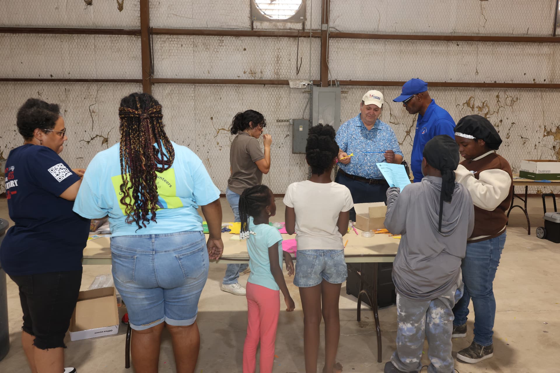 Volunteers and children making crafts at the library activity table.
