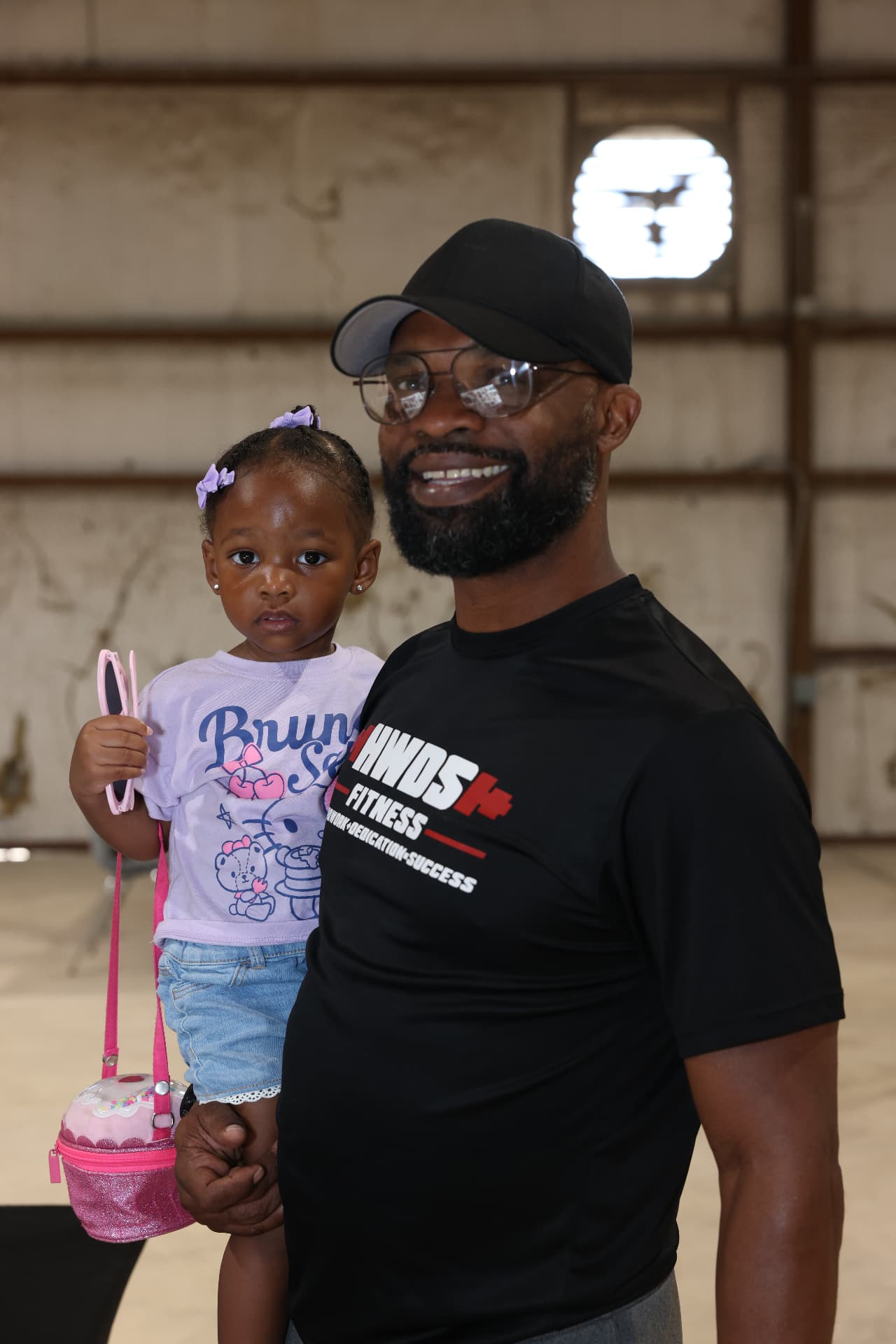 A father holding his young daughter at the festival.