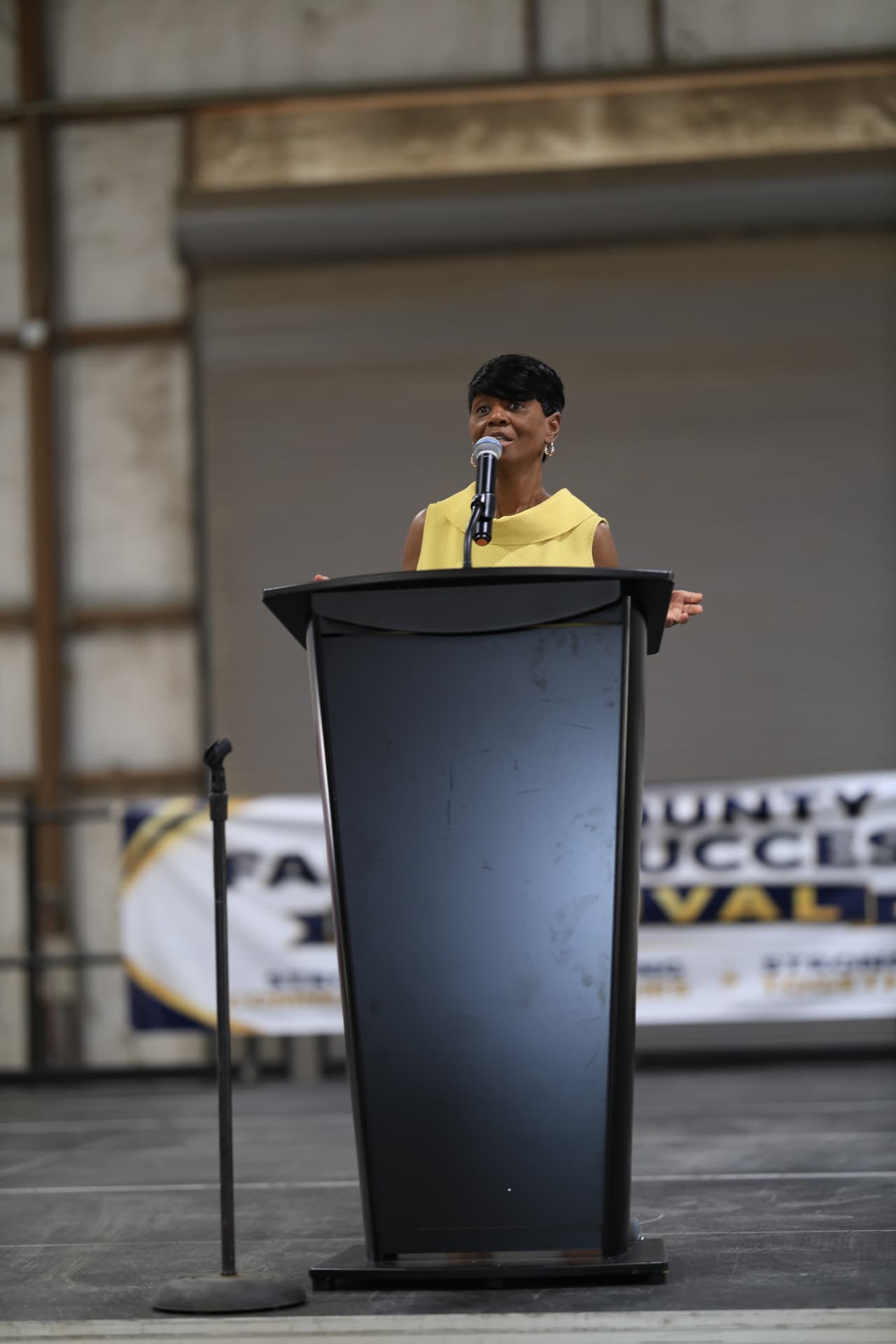 A speaker at the podium in front of the Bell County Family Success Festival banner.