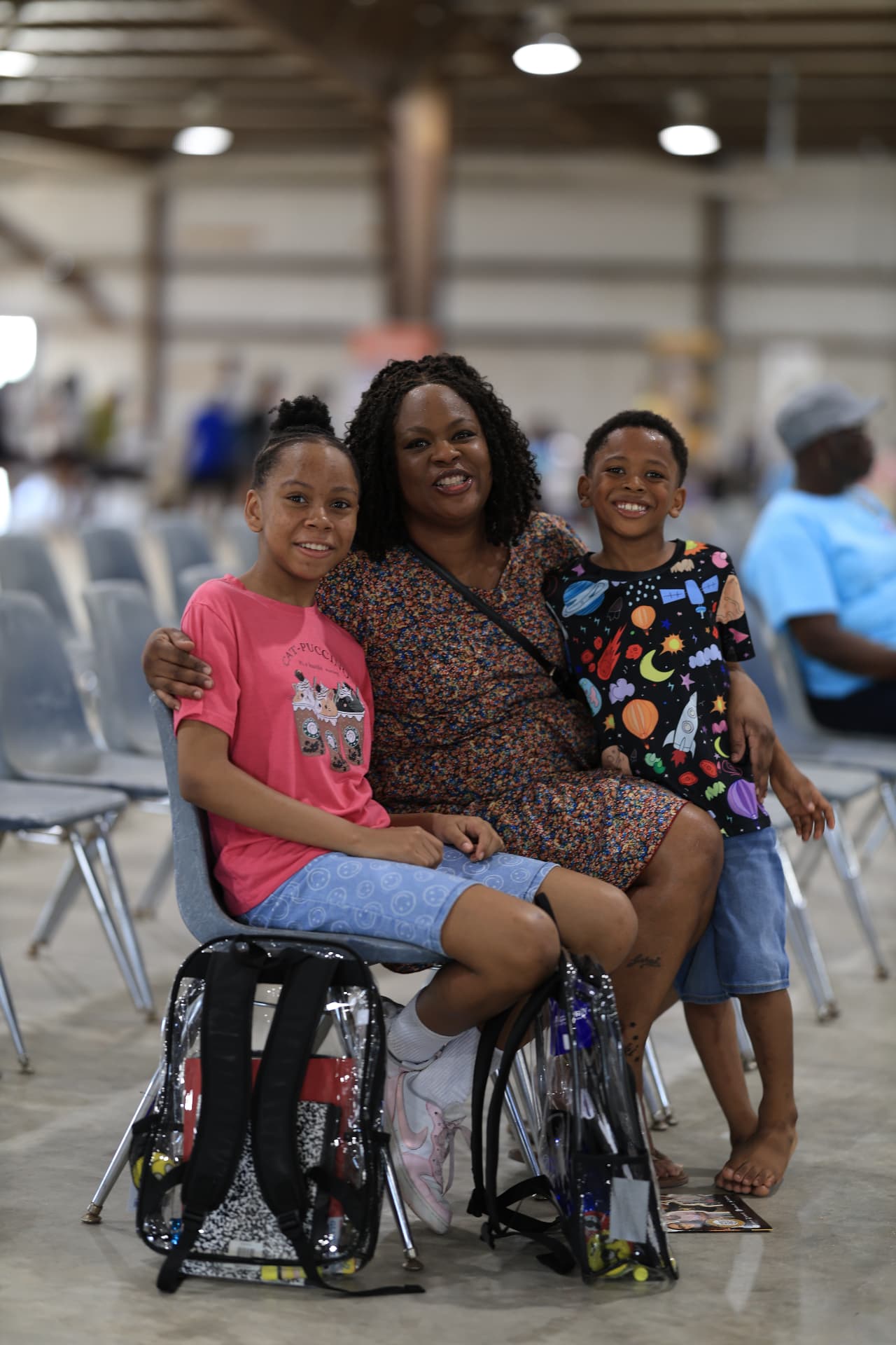 A mother and her two children with clear backpacks at the festival.