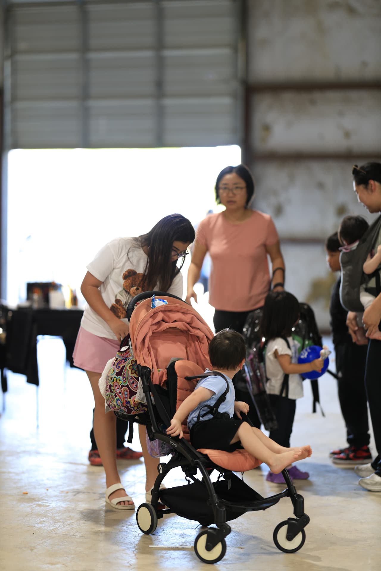 Parents with a stroller and children collecting clear backpacks.