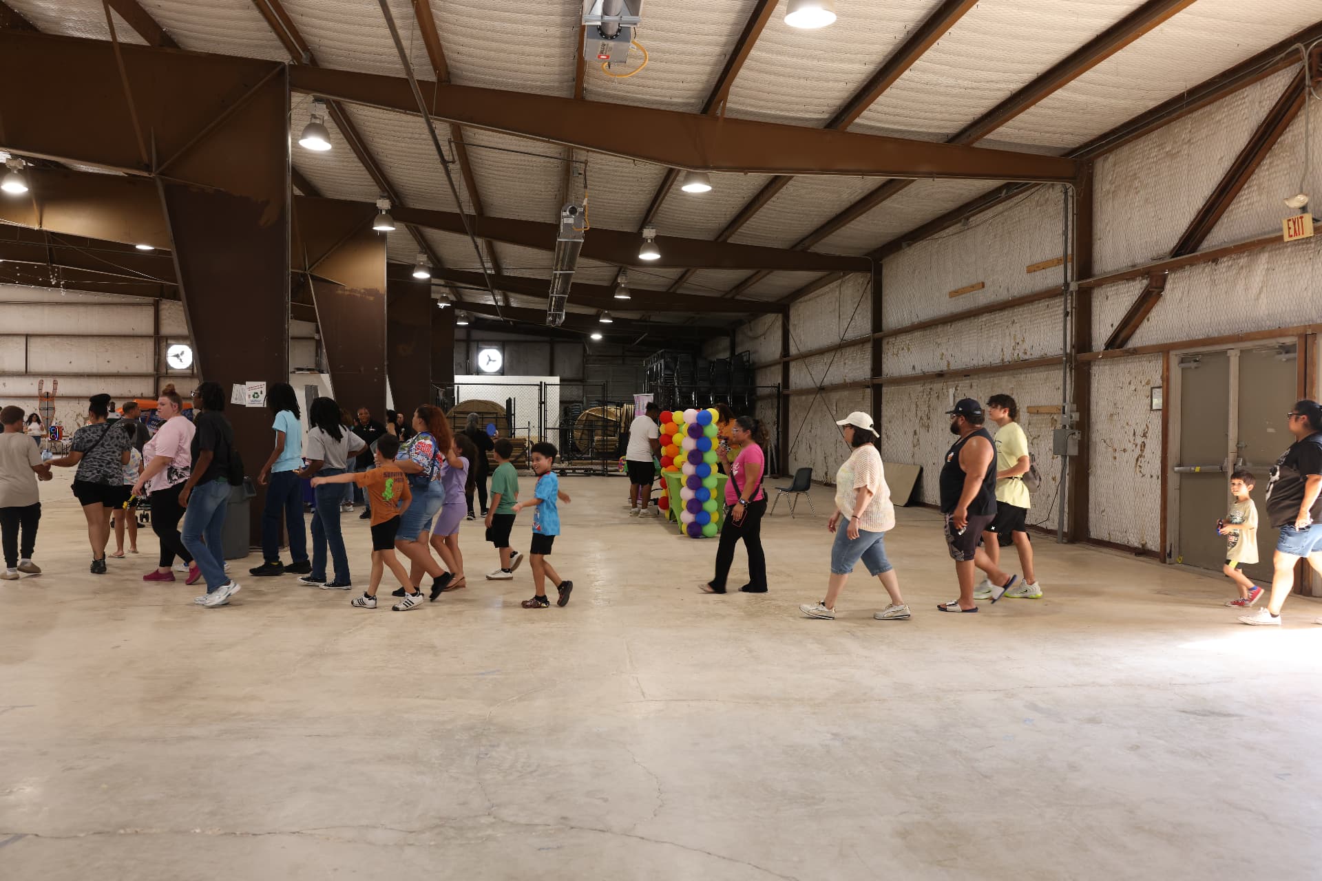 Families walking the venue past the balloon display and activity area.