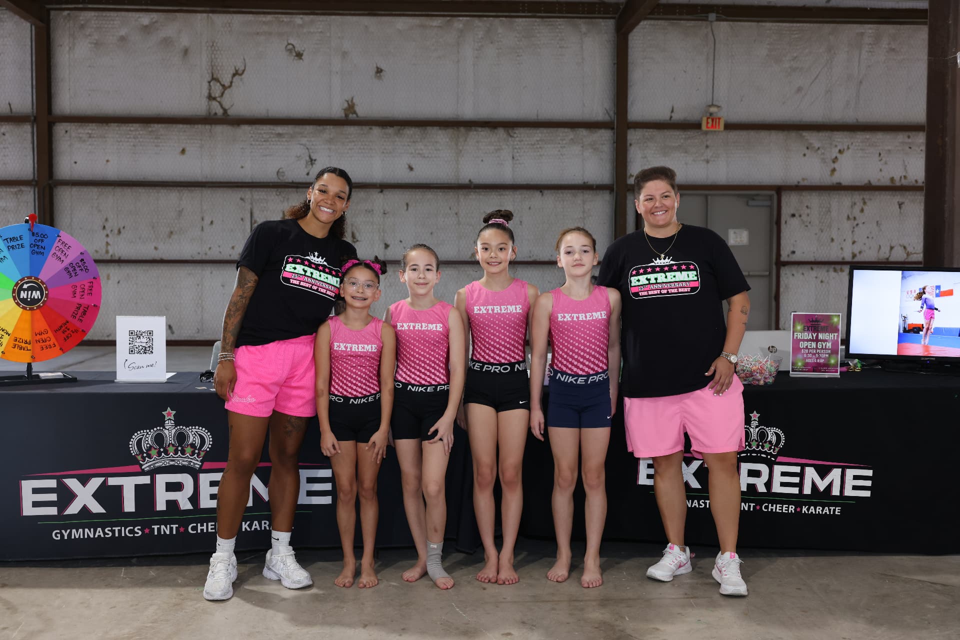 Extreme Gymnastics coaches and young gymnasts posing at their booth.