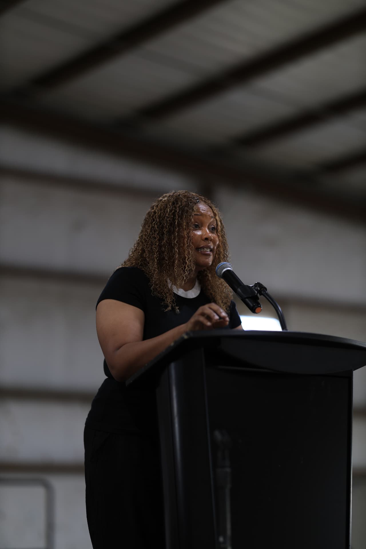 A community speaker addressing the crowd from the podium.