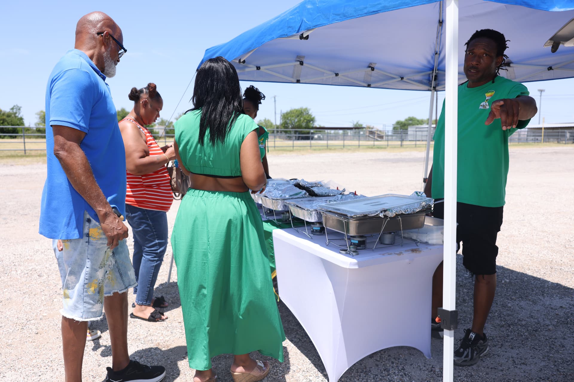 Families ordering food at the Chef Ras vendor tent outside the venue.
