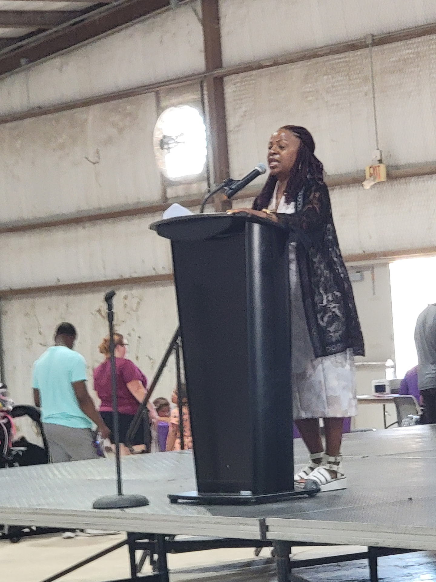 A speaker addressing families from the podium on the community stage.