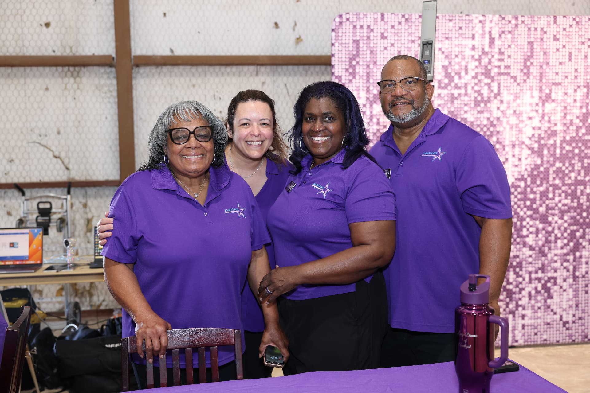 The Amethyst team smiling behind their partner table.
