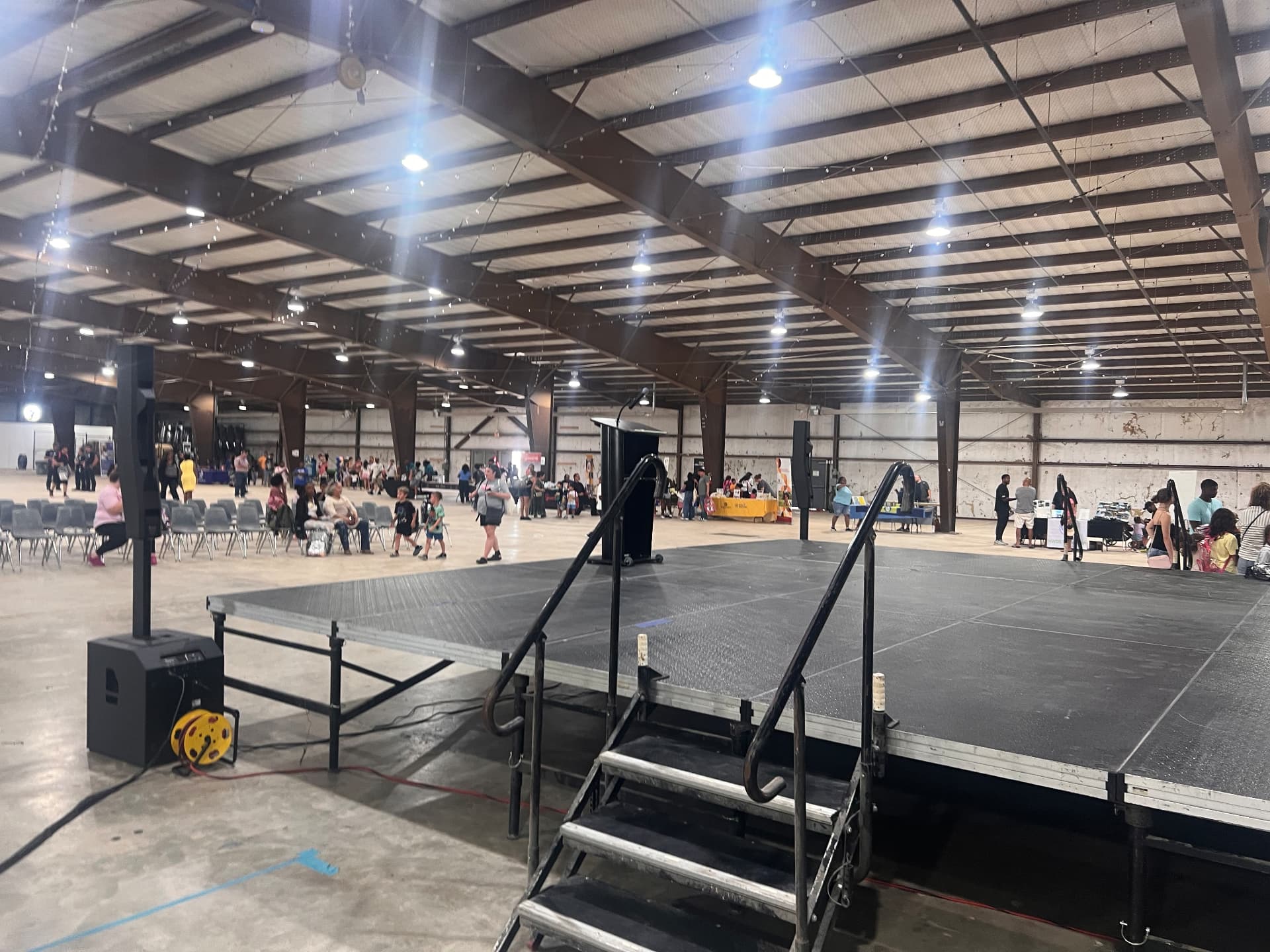 Wide view of the community stage and seating as families fill the venue.