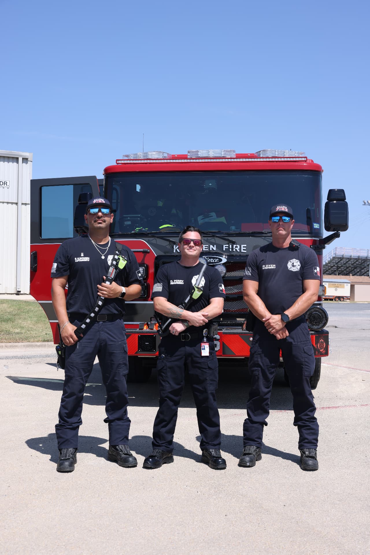 Three Killeen Fire Department firefighters standing in front of their engine.