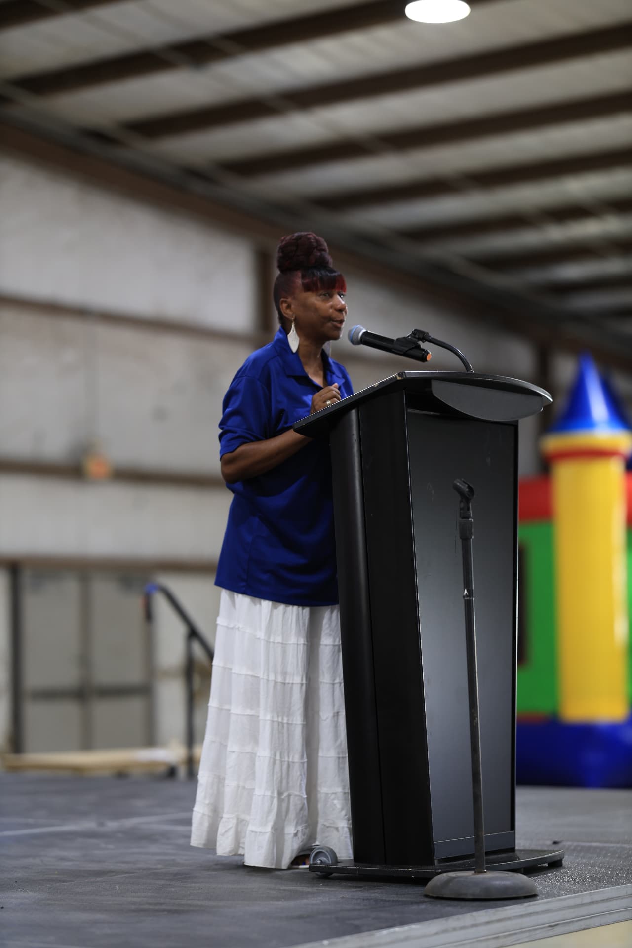 A community leader addressing families from the stage podium.