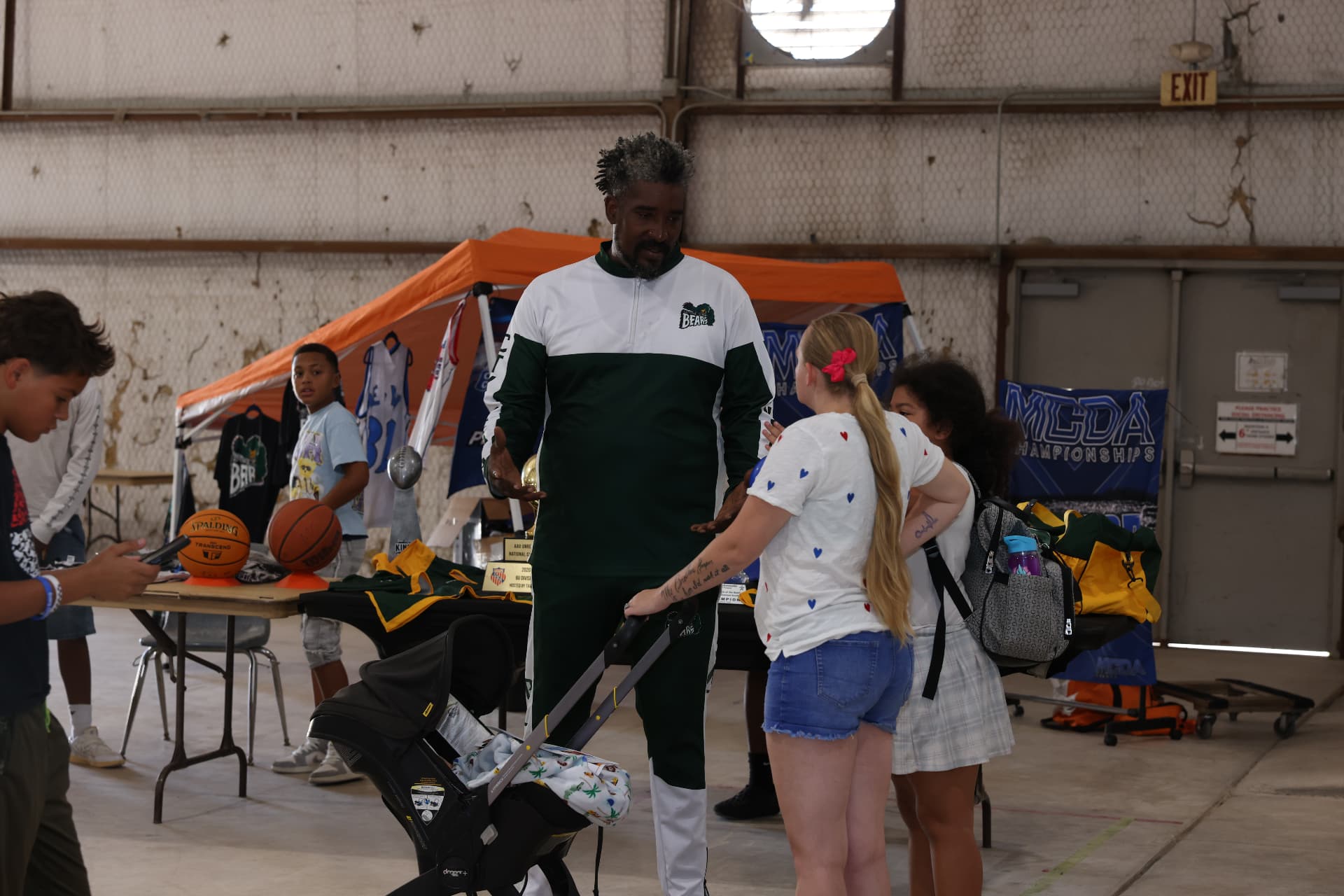 Central Texas Bears coach speaking with families at their sports booth.