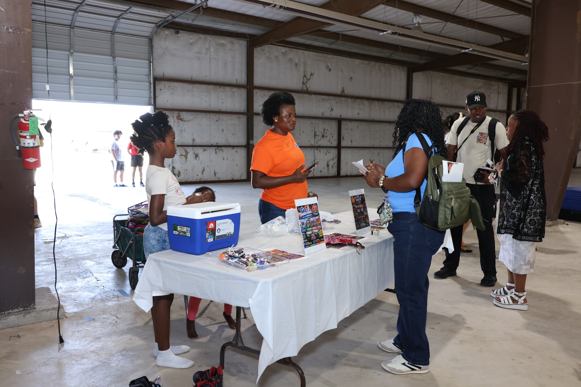 A GoTi Bounce House representative talking with families at her table.
