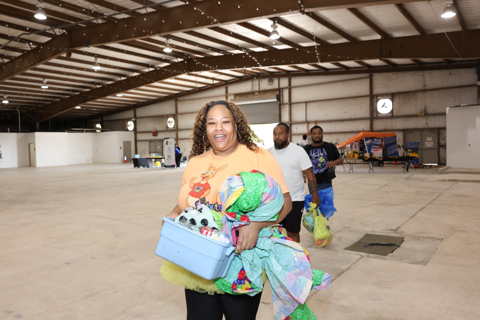 A Tooty Tot volunteer carrying supplies through the venue.