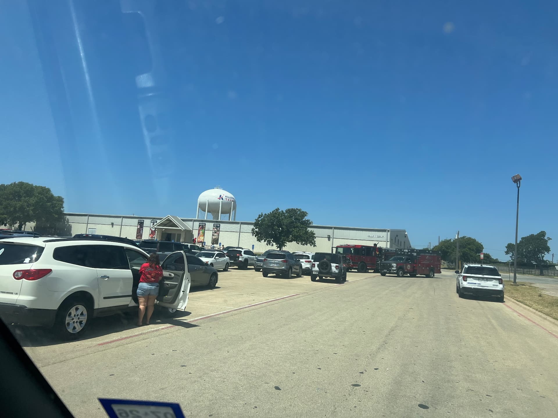 Cars, a fire engine and police unit filling the venue parking lot on festival day.