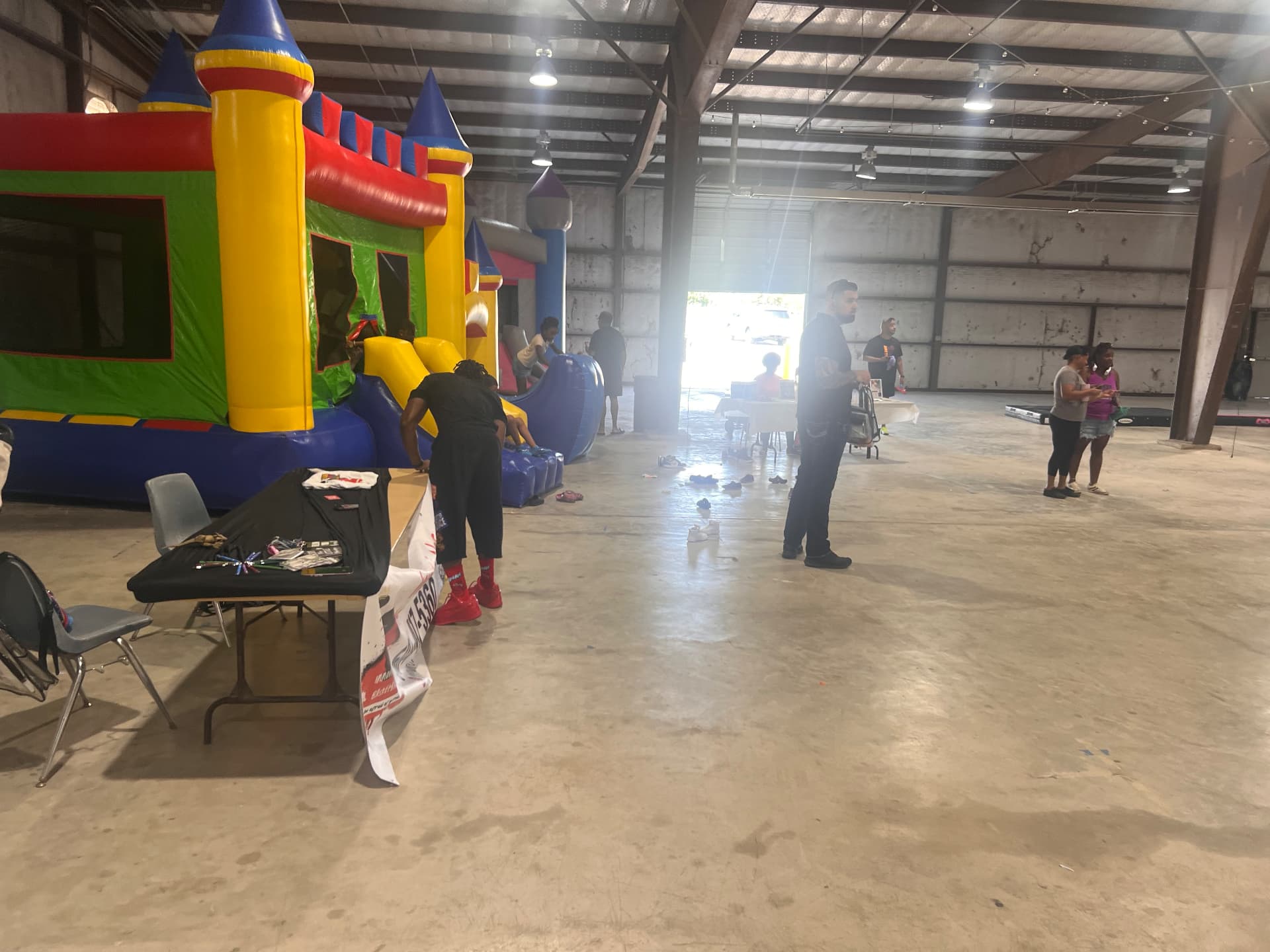 Bounce houses and activity tables set up inside the venue.