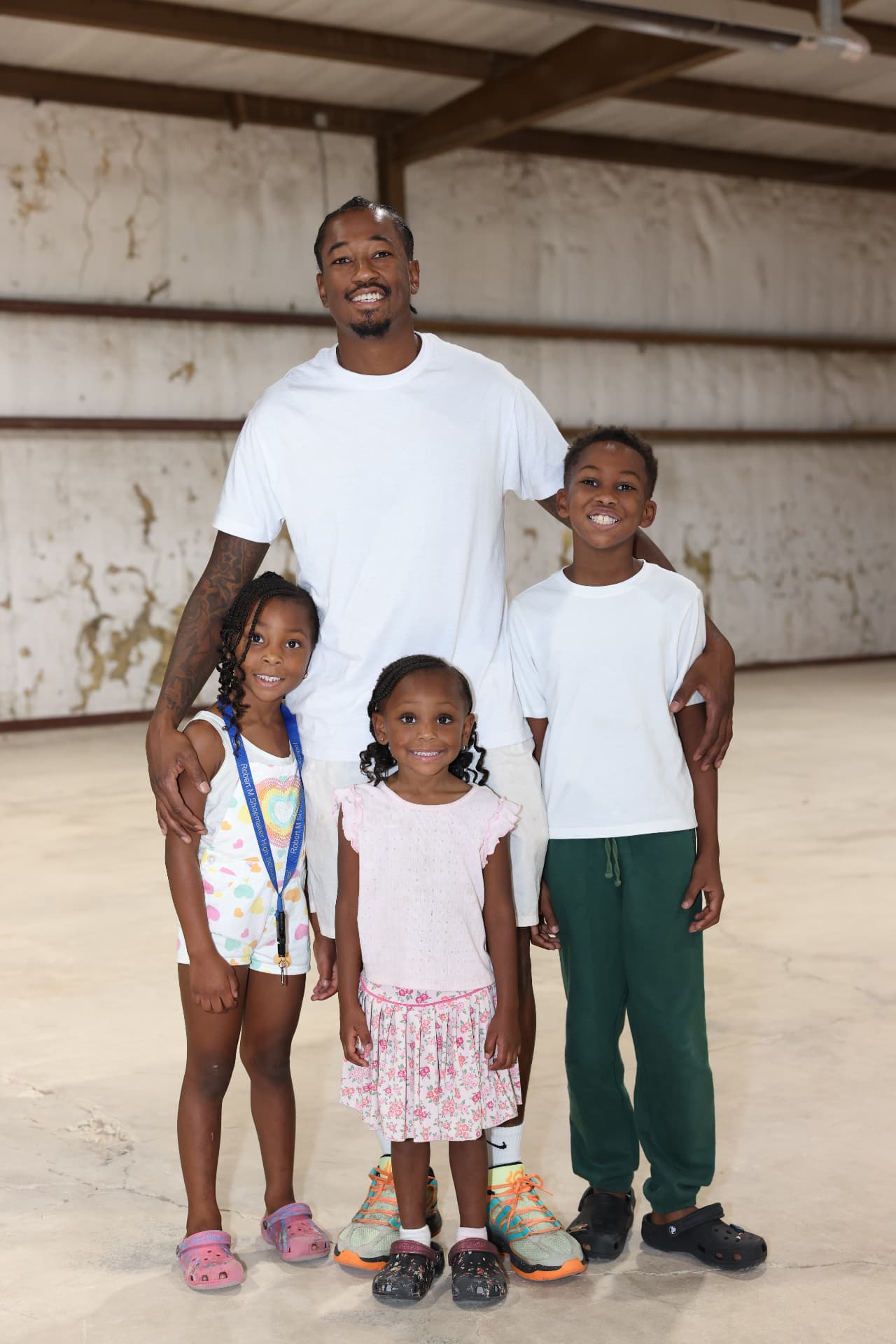 A father with his three children smiling at the festival.