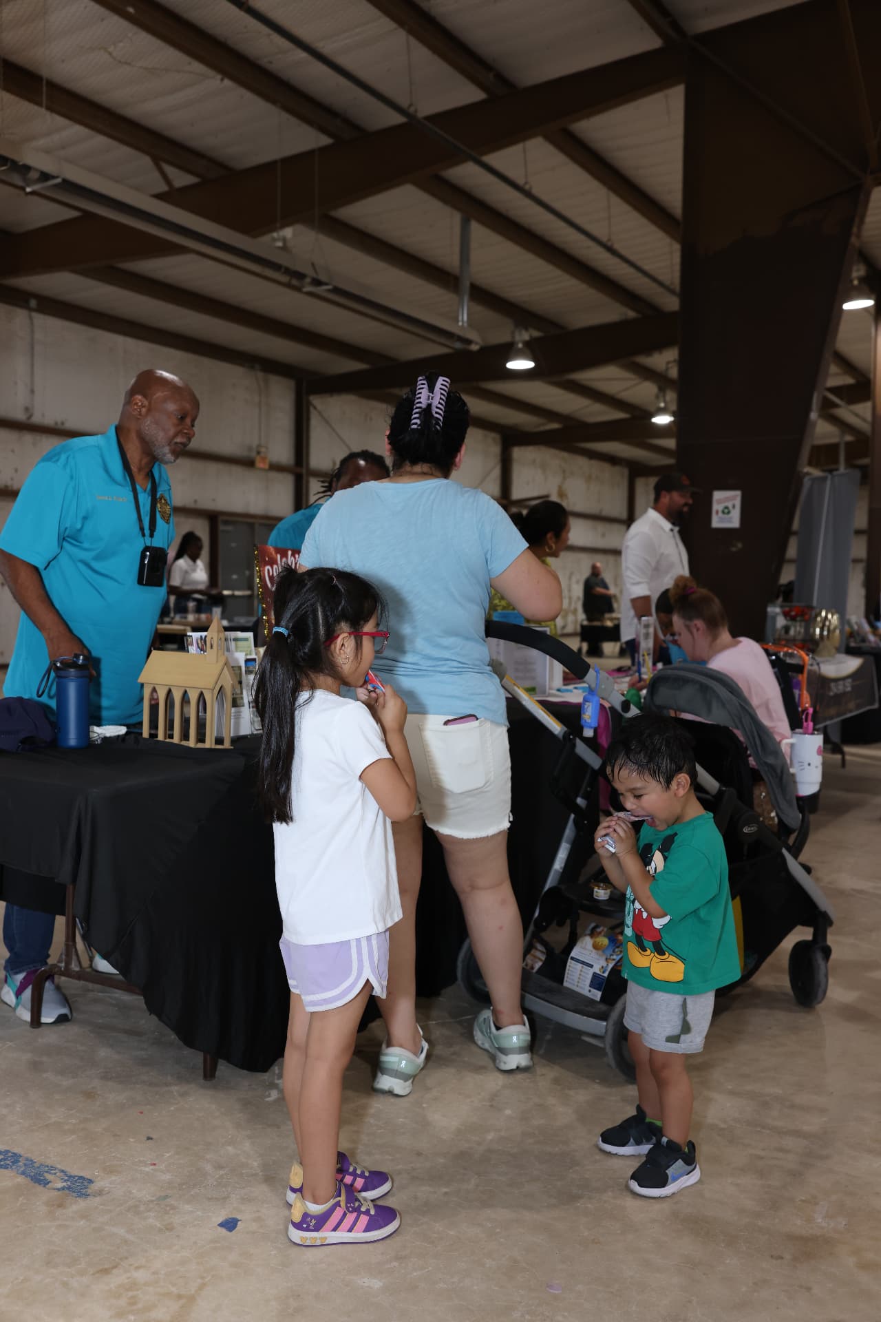 Children and parents visiting a community resource table.
