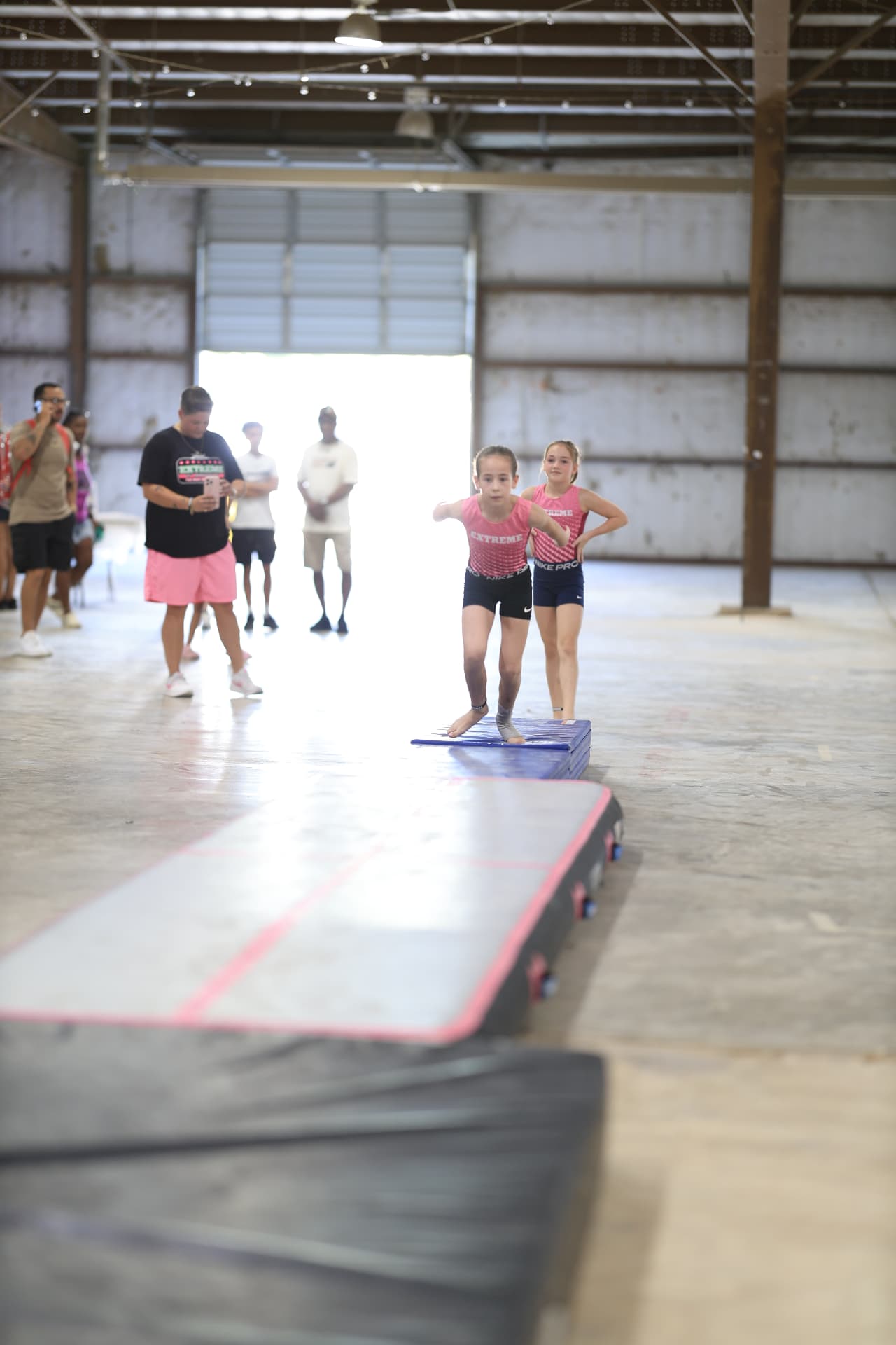 Young gymnasts from Extreme warming up on the tumbling mat.